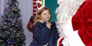 A little girl meeting Santa Claus in his Grotto