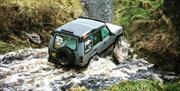 Land Rover driving through river
