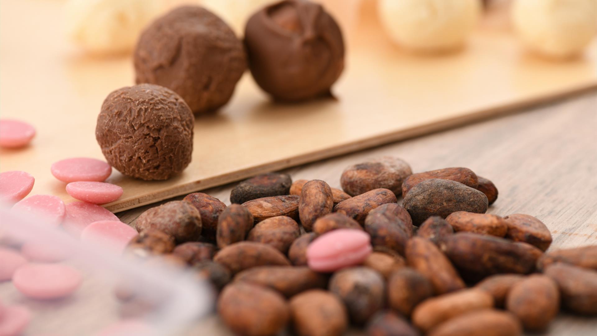 Chocolate truffles sit on a serving board with cacao nips sitting infront Chocolate truffles sit on a serving board with cacao nips sitting infront