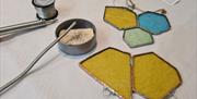 pieces of colourful stained glass in hexagonal shapes, with copper plated edges