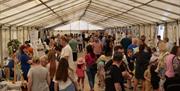 crowds browsing through an indoor market with various stalls at the Ballymoney Show