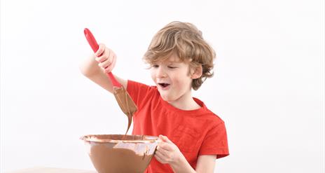 Boy enjoys mixing chocolate at The Chocolate Manor
