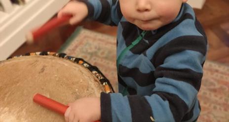 Toddler banging on a drum