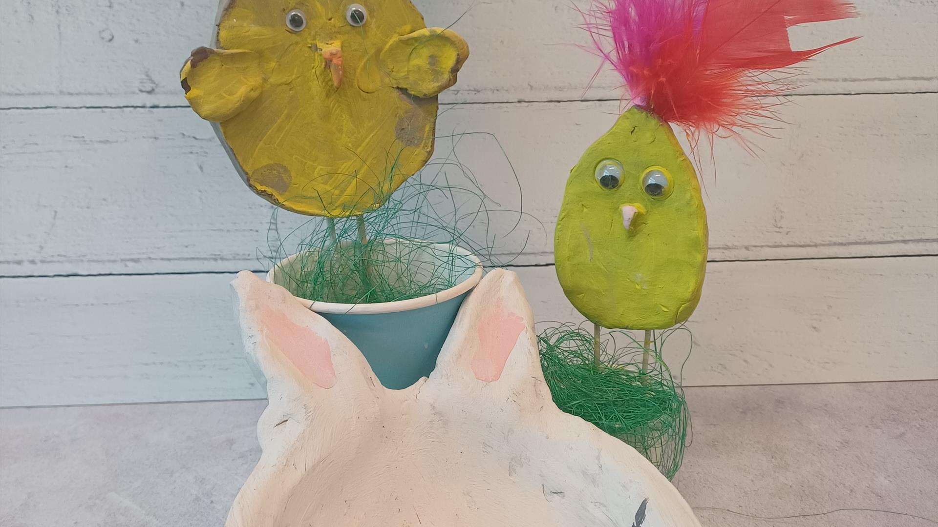 image of a handmade clay bowl in the shape of a bunny with clay chicks on sticks painted yellow in the background. image of a handmade clay bowl in the shape of a bunny with clay chicks on sticks painted yellow in the background.