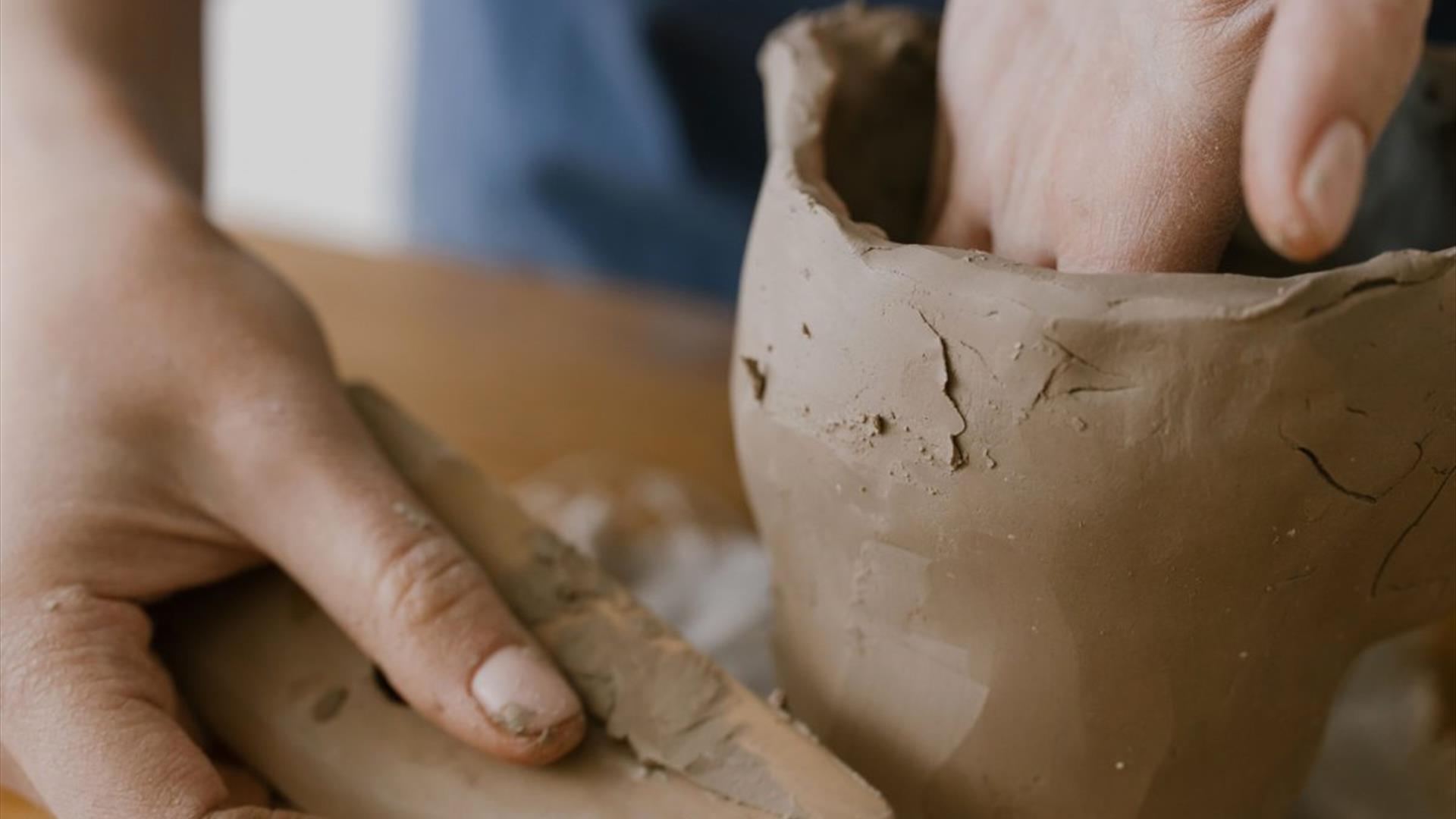 a person's hands sculpt a container made from clay a person's hands sculpt a container made from clay