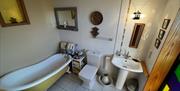 The bathroom is ensuite off the yellow bedroom and is equipped with a claw foot cast iron bath.