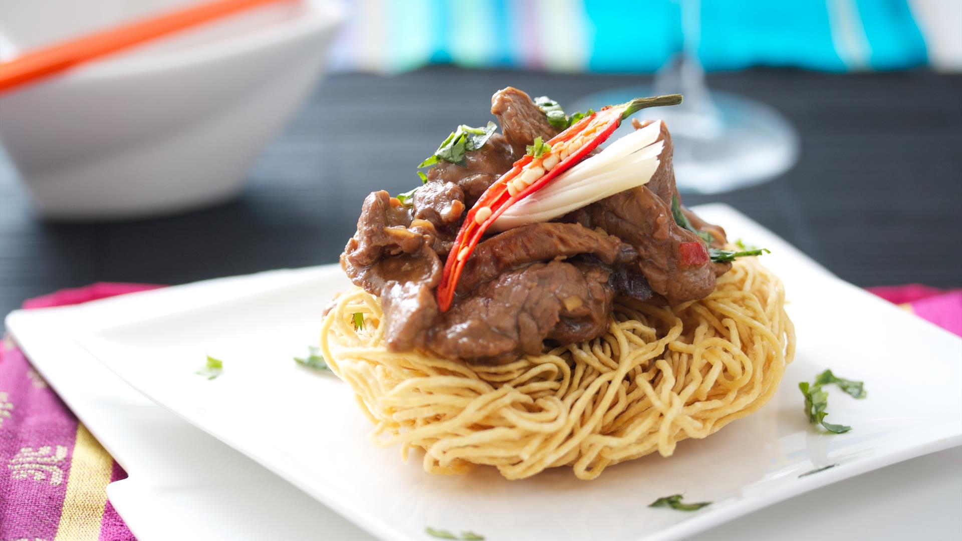 an Asian-inspired food dish with beef on top of noodles an Asian-inspired food dish with beef on top of noodles