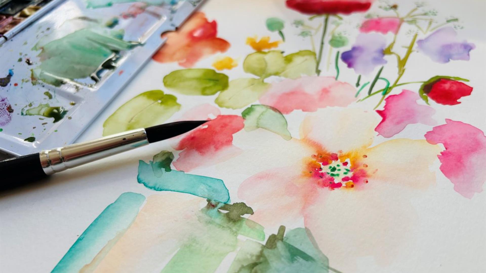 painting of flowers using watercolour paints rests beneath a small paintbrush and watercolour palette painting of flowers using watercolour paints rests beneath a small paintbrush and watercolour palette