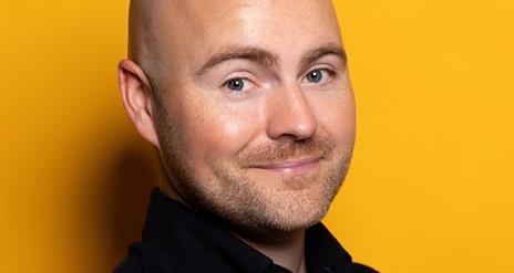 image of comedian Paddy Raff against a yellow background