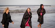 Guide and members of the group in dry robes enjoying the Mussenden Unwind experience