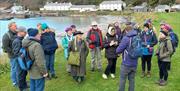 people gather outside on Rathlin Island listening to a tour guide people gather outside on Rathlin Island listening to a tour guide