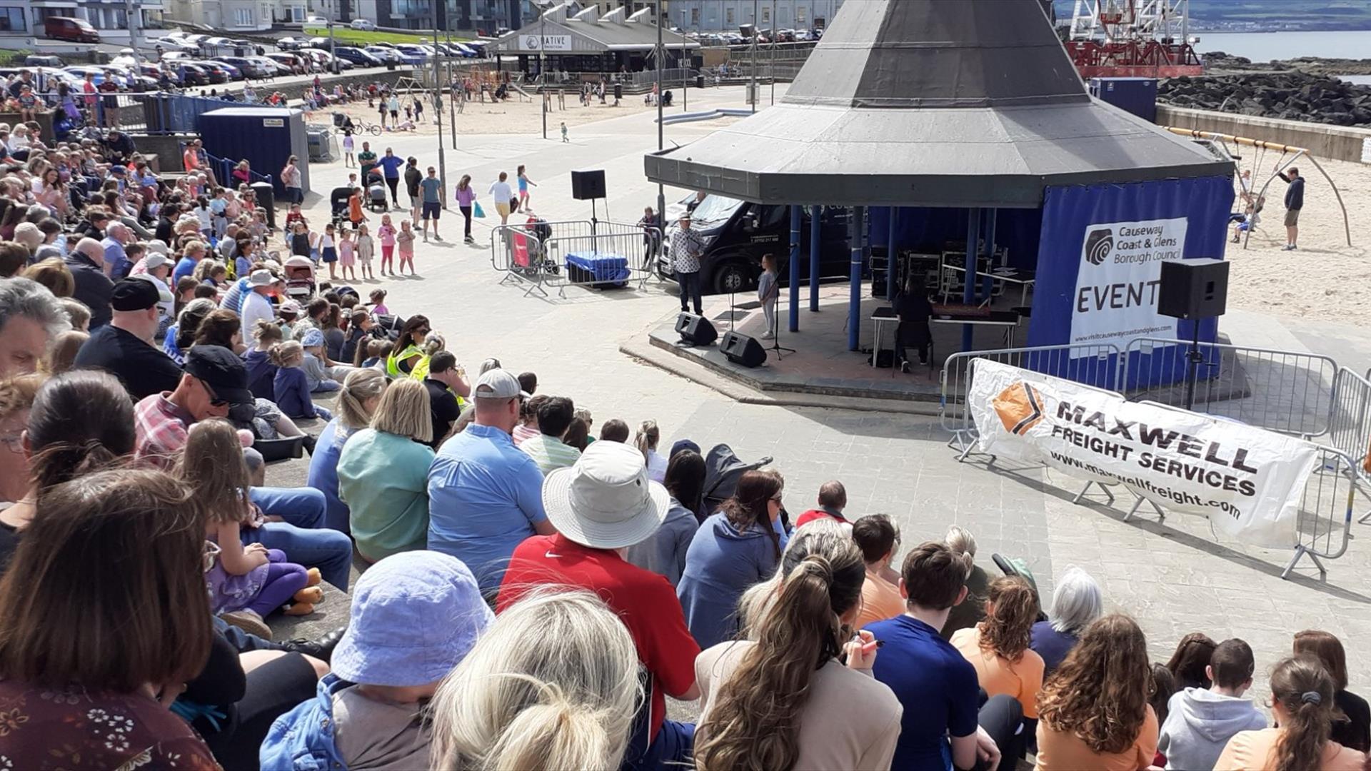 Crowds being entertained by performers at the bandstand