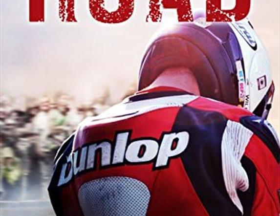 Movie poster from the film Road with the back of a motorcyclist feature the word Dunlop on his back.