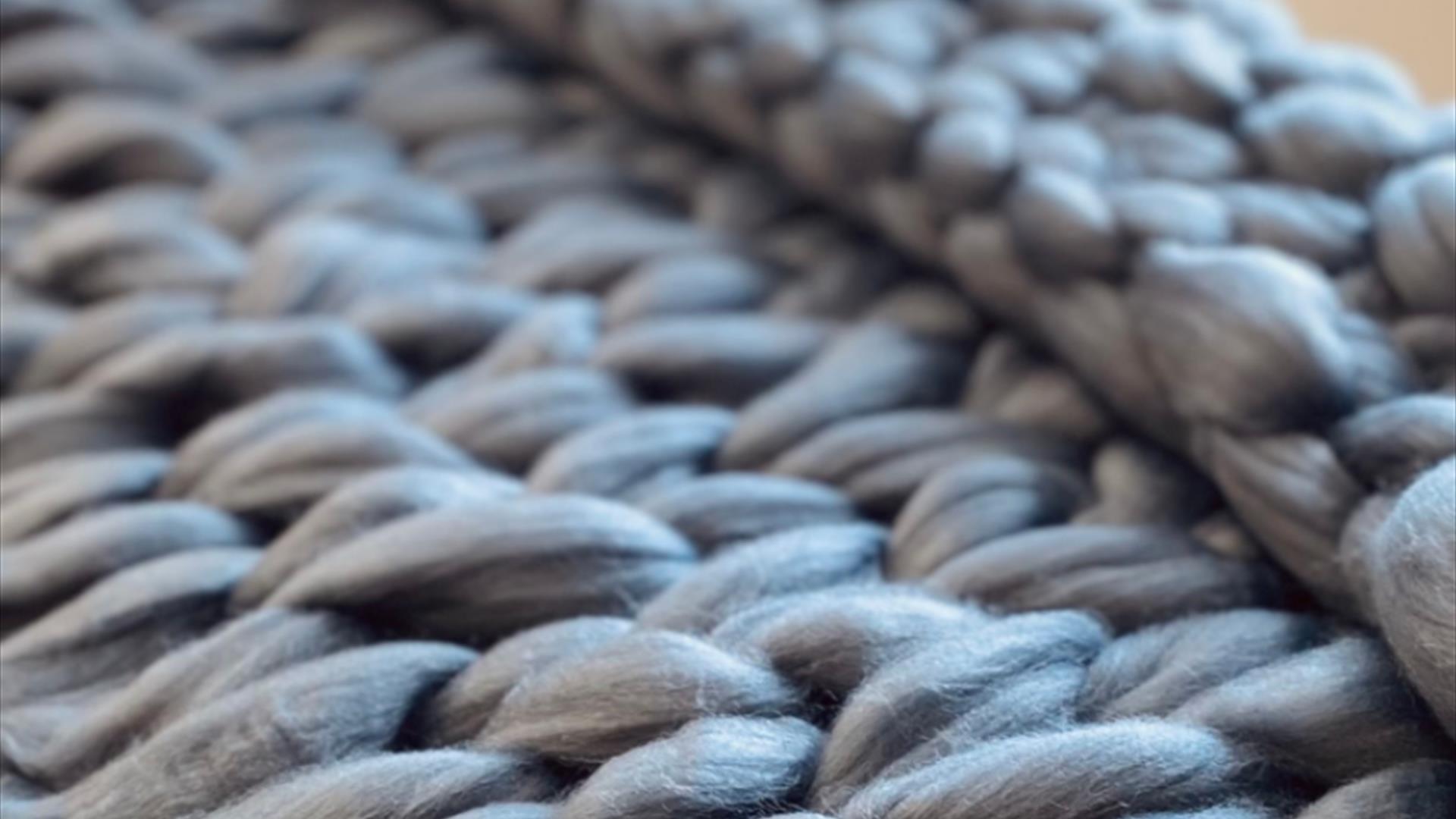 close up photo of a knit-woven throw blanket, highlighting the individual fibers close up photo of a knit-woven throw blanket, highlighting the individual fibers