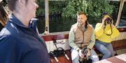 Guests use binoculars to get a better view of wildlife on the river banks Guests use binoculars to get a better view of wildlife on the river banks