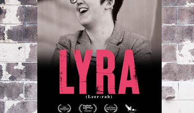 Lyra McKee wearing black rimmed glasses and smiling on a poster