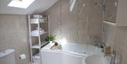 The bathroom has a built in jacuzzi style spa bath, electric shower, towel radiator, electric shaving point and skylight.