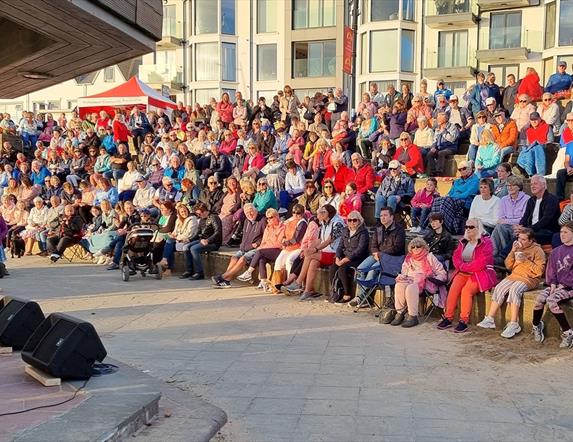 Elvis Show at Red Sails Festival with a full crowd sitting in front of him