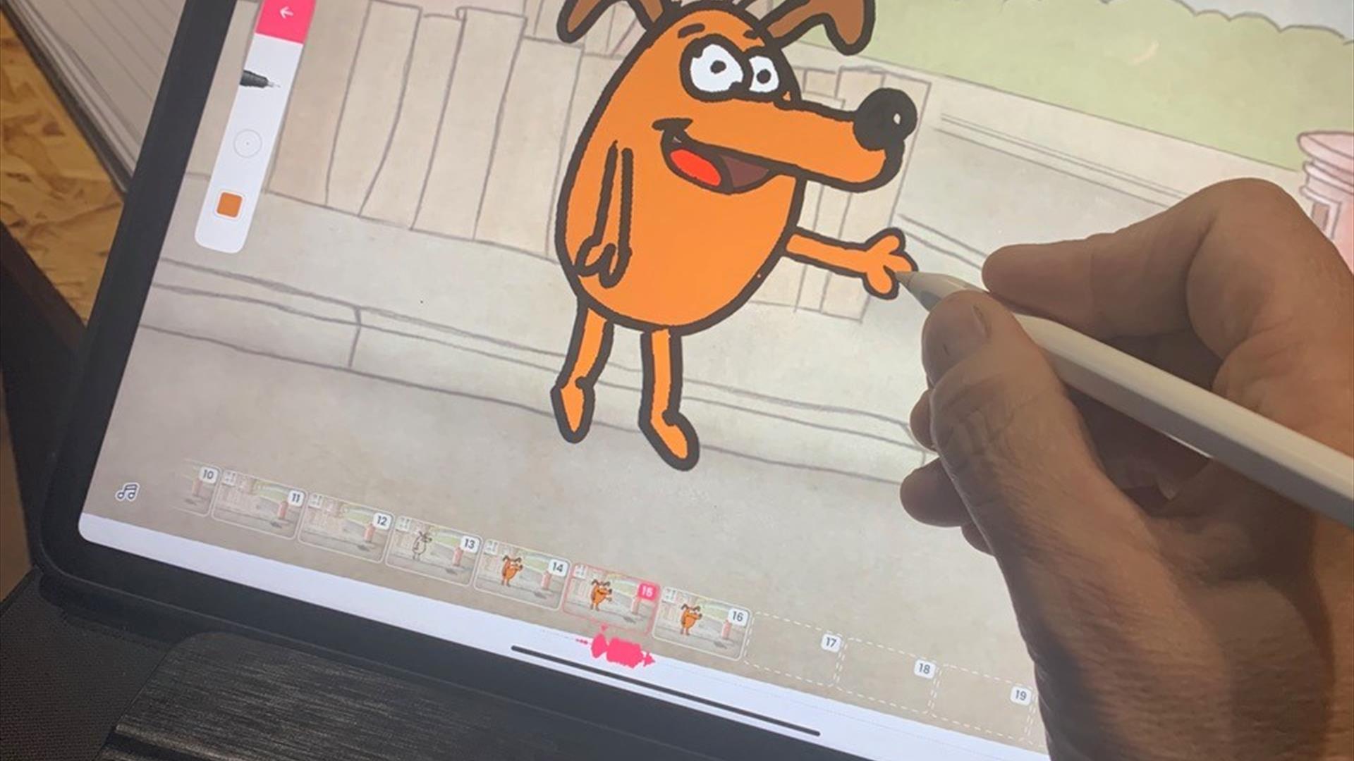 Image shows a hand drawing a cartoon dog on a computer screen