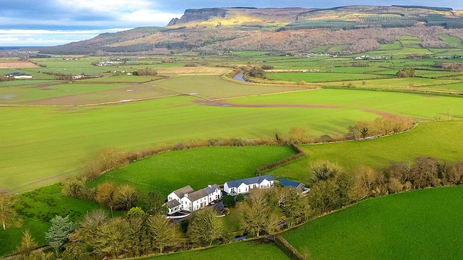 Aerial view of The Willows estate surrounded by green fields at the foot of Binevenagh Mountain near Limavady. Aerial view of The Willows estate surrounded by green fields at the foot of Binevenagh Mountain near Limavady.