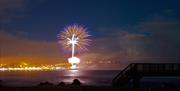 Image shows fireworks lighting up the sky above Ballycastle Beach
