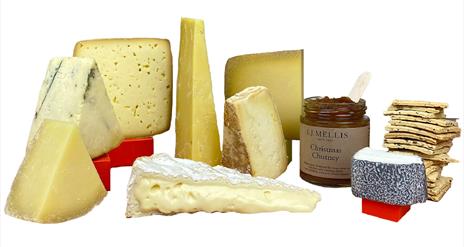 a selection of different cheeses pictured with chutney and crackers