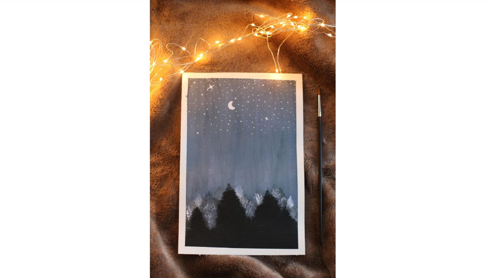 a painting of a nighttime landscape featuring shadowy trees and the moon and the stars rests on a faux fur blanket with fairy lights strewn on top a painting of a nighttime landscape featuring shadowy trees and the moon and the stars rests on a faux fur blanket with fairy lights strewn on top