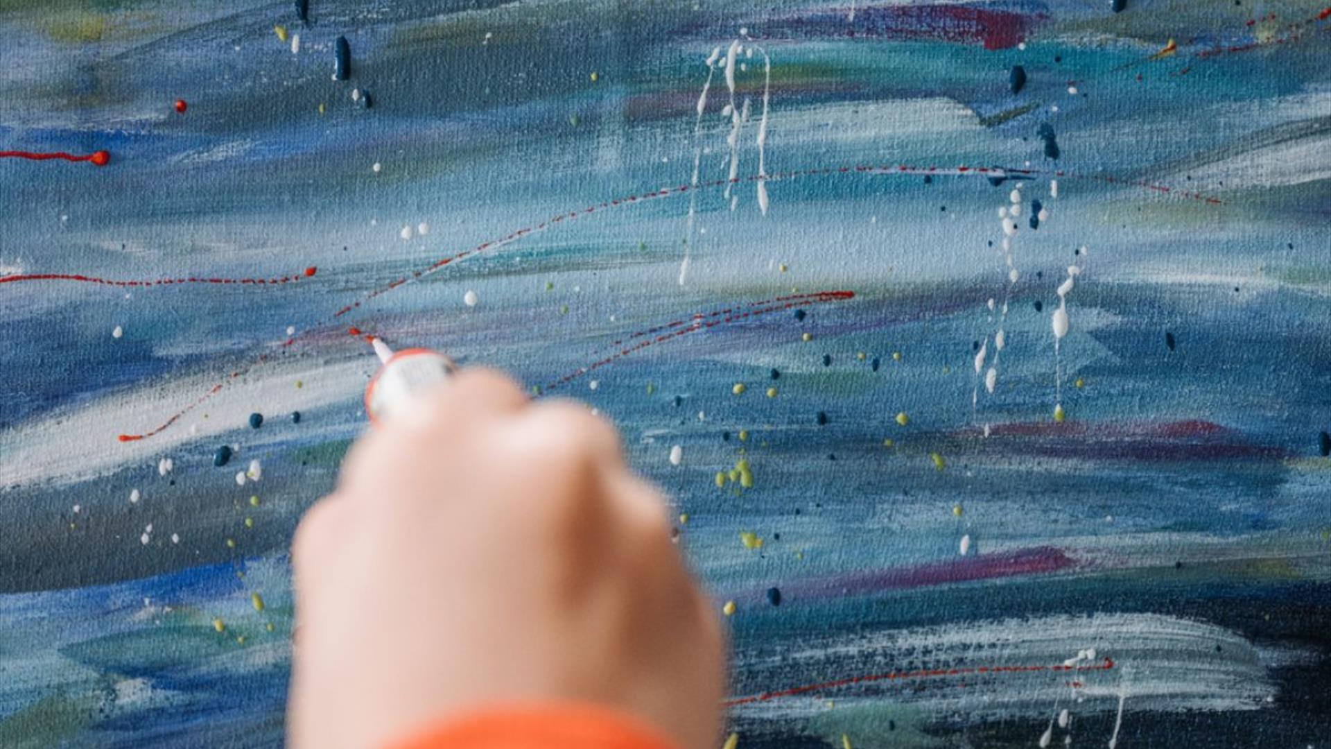 a person uses their hand paint fine lines on a painted canvas a person uses their hand paint fine lines on a painted canvas