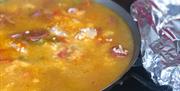 a close up of a simmering paella dish