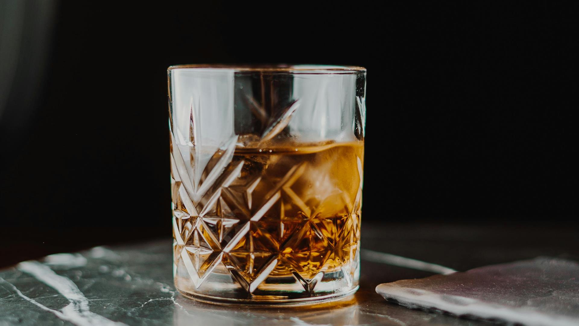 a glass of whiskey sitting on a table a glass of whiskey sitting on a table