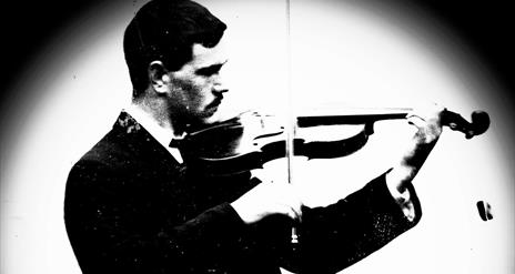 black and white image of Sam Henry playing the violin