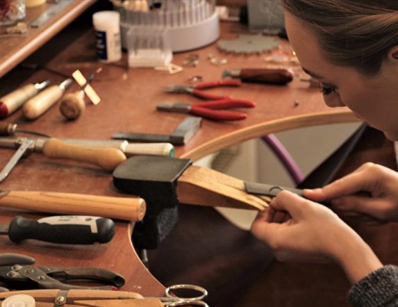 a jeweller works at crafting her creations in a workshop