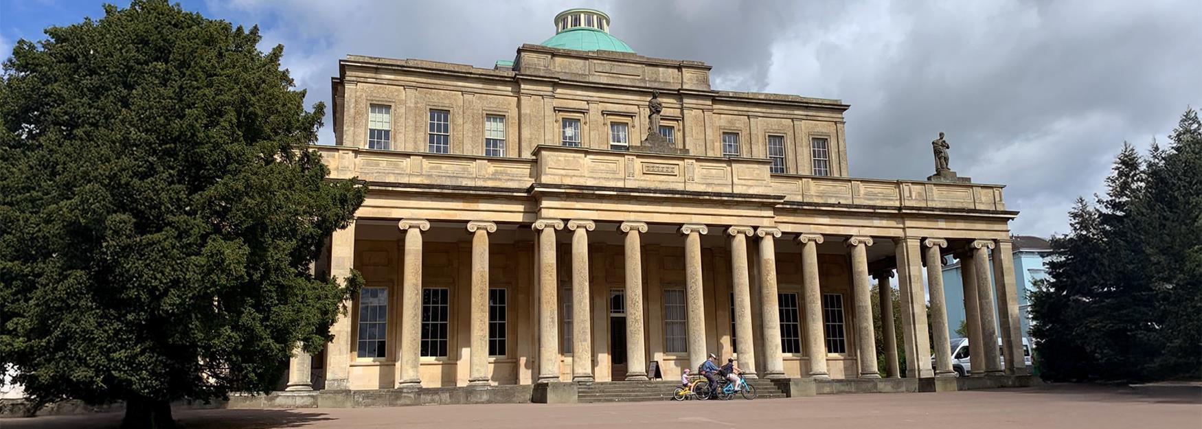 A family on bikes outside Pittville Pump Room