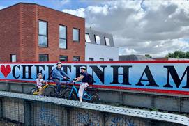 Cyclists in front of a Cheltenham sign