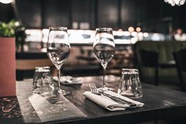 A set dining table at Brasserie Blanc Cheltenham, with two wine glasses and a menu