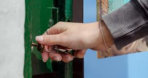 Hand unlocking a door.