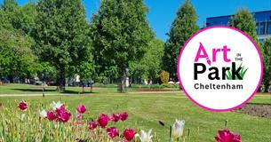 A photo of the imperial gardens park where art in the park will take place showing white and pink tulips in the foreground, tall green trees against a