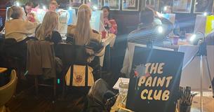 A group of people painting with The Paint Club
