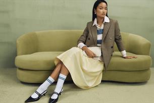 Model sitting on a pistachio coloured sofa