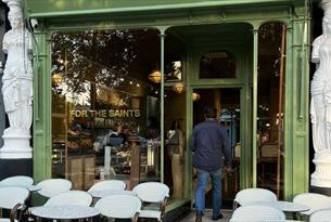 Glass and green painted front of For the Saints espress bar, which stands between two of Montpellier Walk's famous Caryatid statues