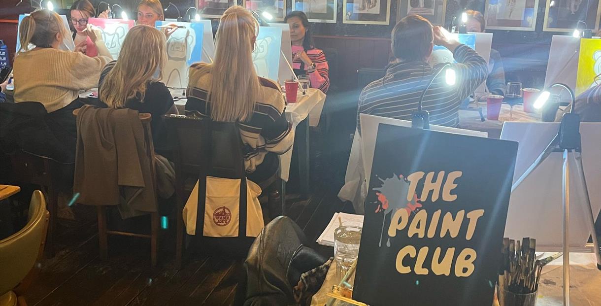 A group of people painting with The Paint Club