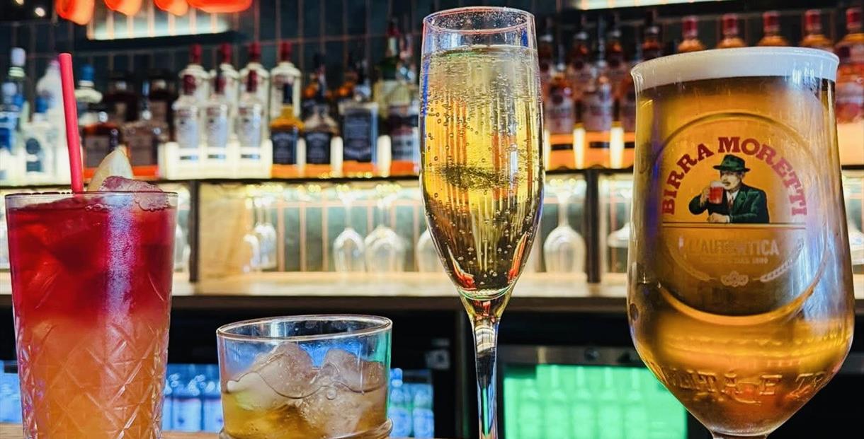Two cocktails, a flute of champagne and a pint of beer on the bar at The Miller Cheltenham