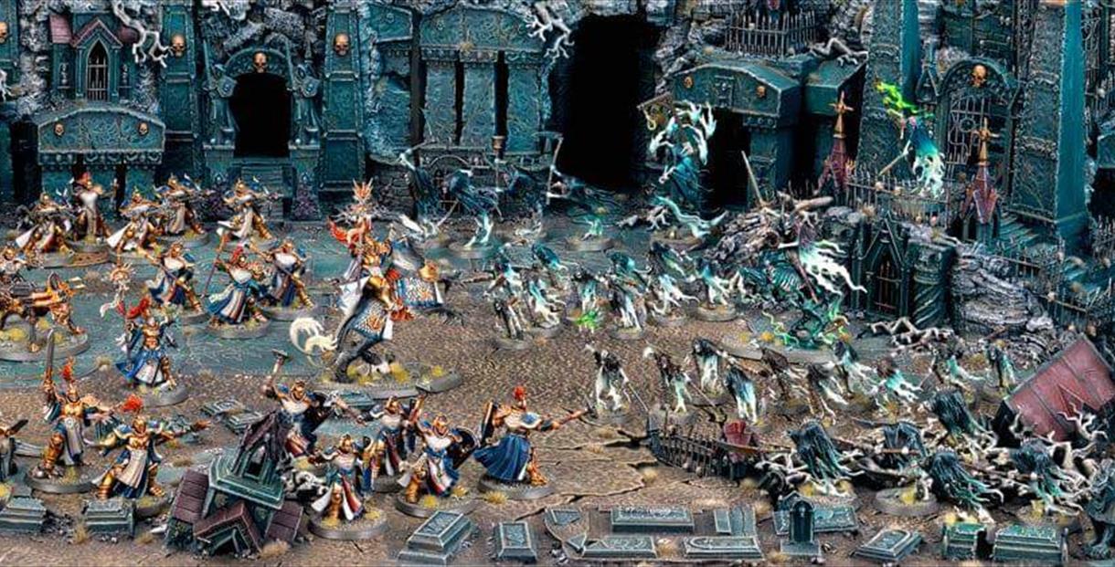 Scene filled with Warhammer models.