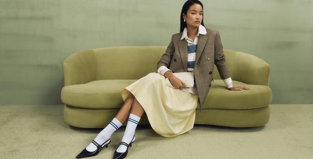 Model sitting on a pistachio coloured sofa