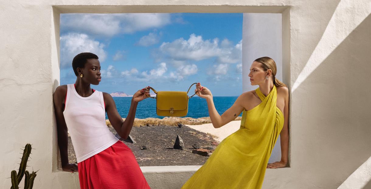 Two models holding a handbag