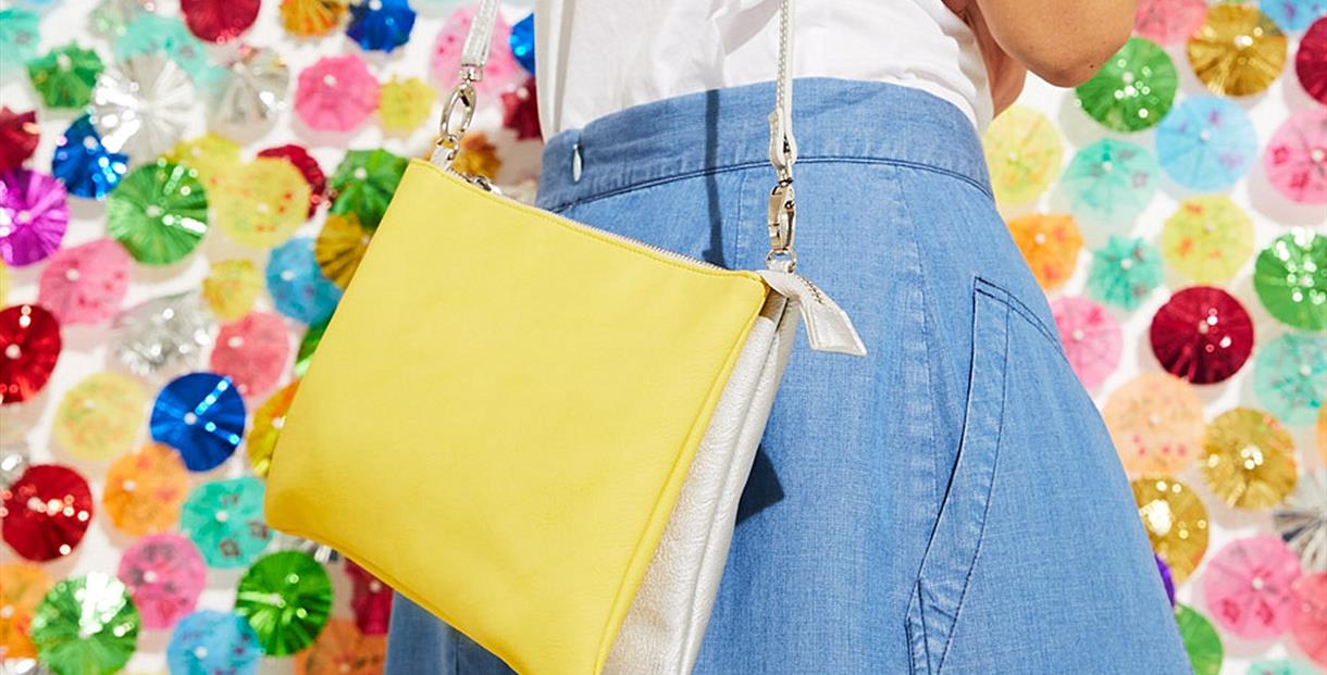 Model in a demin skirt with yellow handbag