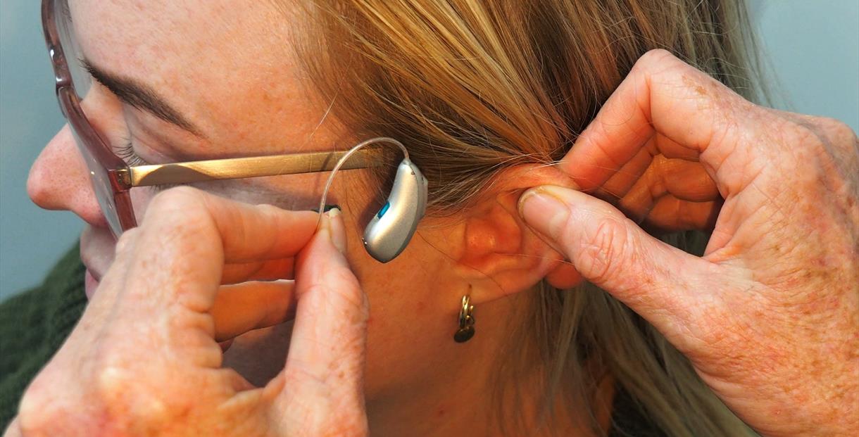 Woman receiving a hearing aid