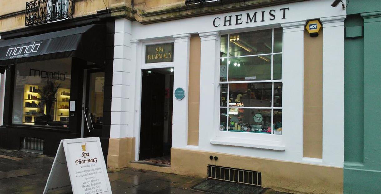 Spa Pharmacy's traditional stone shop front with blue plaque