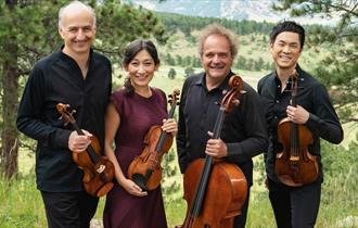 Takacs Quartet stood outside, holding violins and a cello