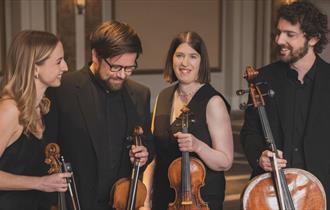 Castalian Quartet in formal black dress holding violins and cellos.